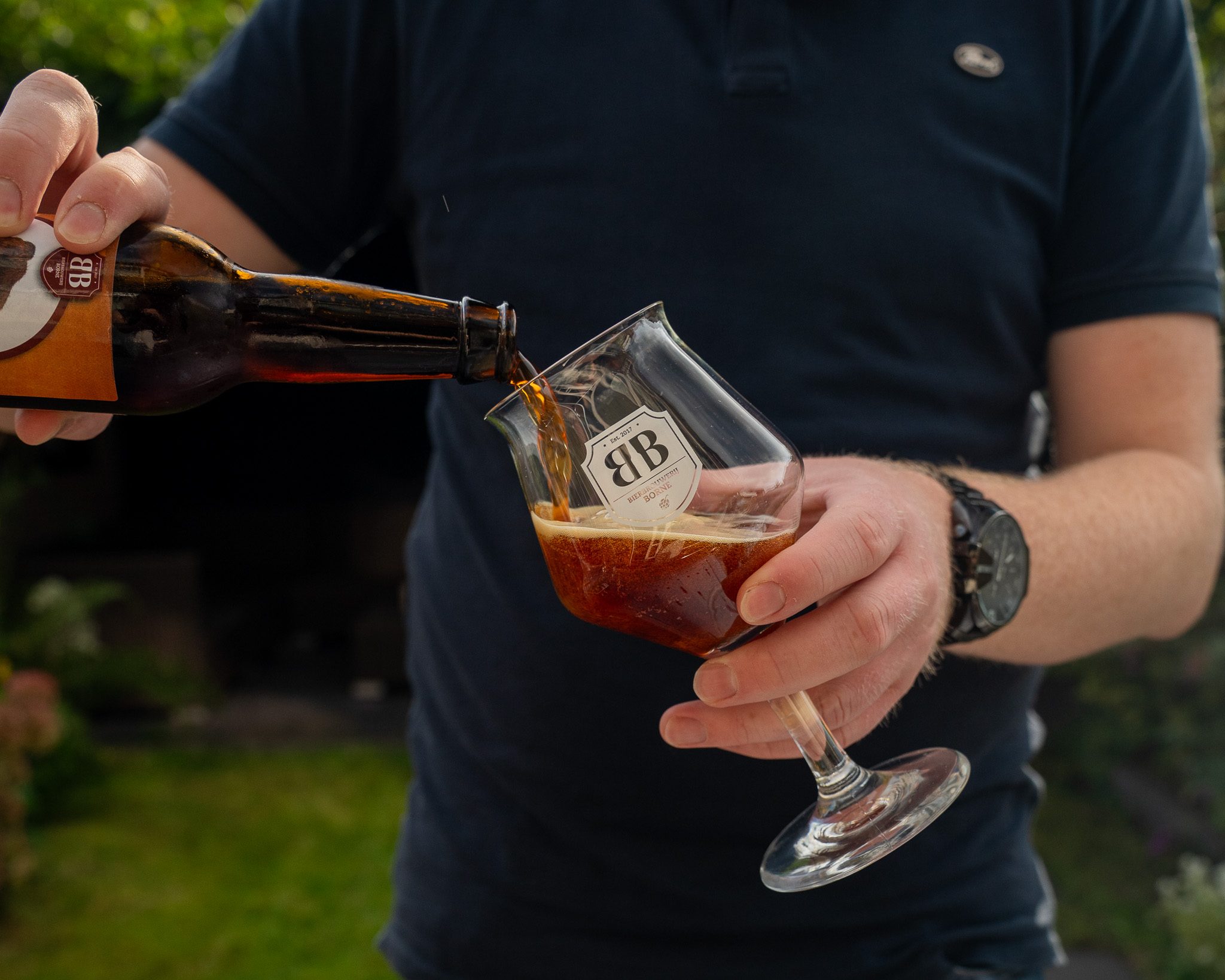 Donker bier wordt ingeschonken in een proefglas van Bierbrouwerij Borne